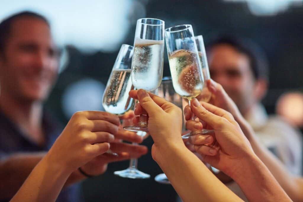 People clinking champagne glasses at an event