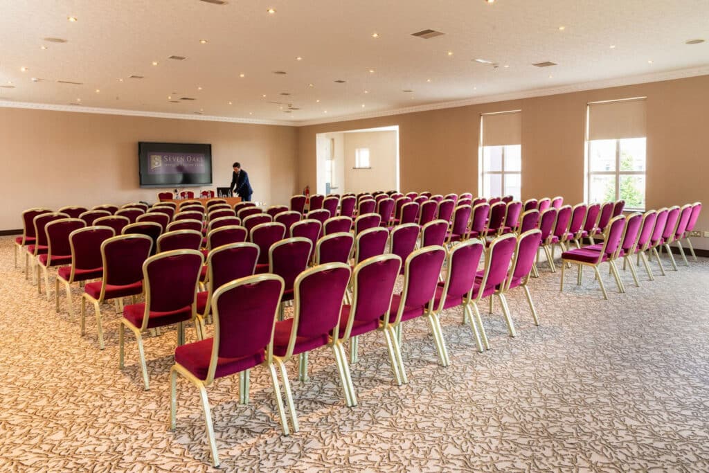 View of conference room from the back of the room facing towards man